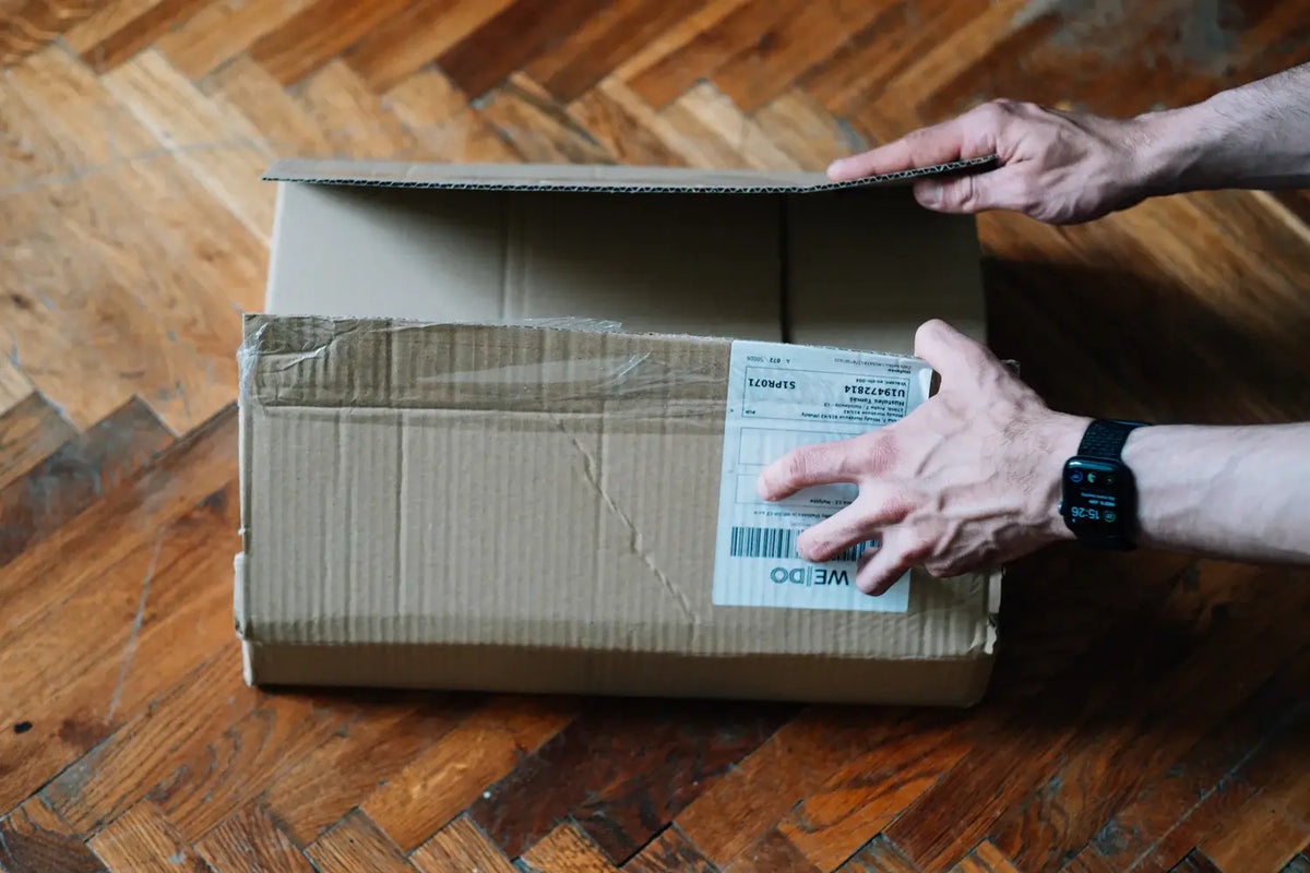 Brown box being opened by someones hands